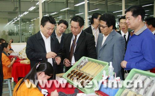 龙岗区长张备(左一),副区长熊小平(右二)等在高华眼镜厂了解企业生产